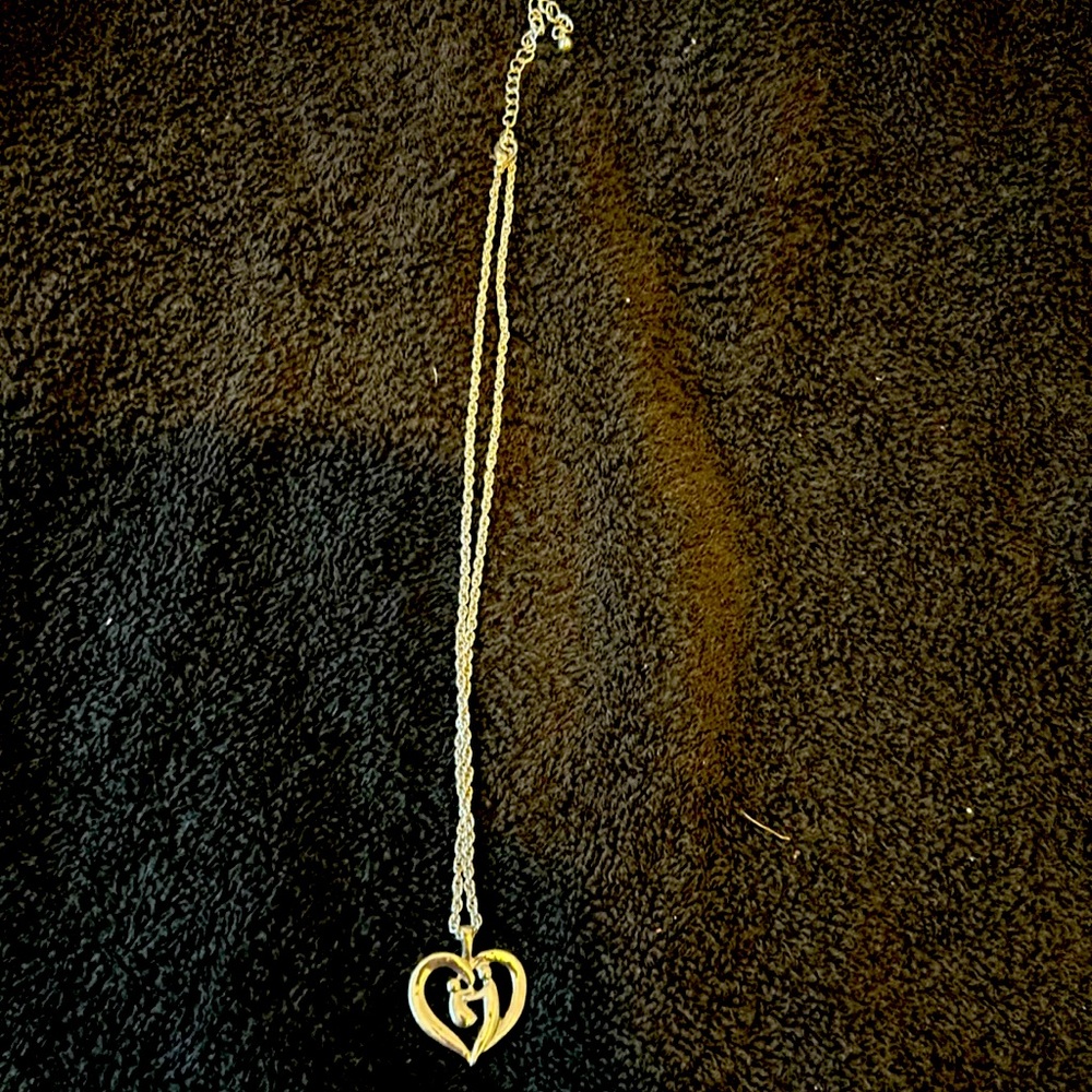 Silver chain necklace with a heart pendant with a mom and a baby on it